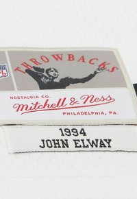 Mitchell & Ness 1994 John Elway NFL Throwbacks Etikett mit einer Vintage-Fußballspieler-Grafik und dem Standort Philadelphia, PA.