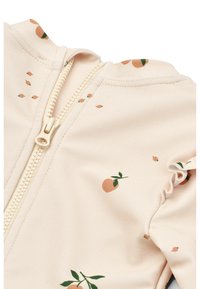 T-shirt de bain pêche clair avec une fermeture éclair blanche, présentant un motif de petites oranges et de feuilles vertes. Tissu doux avec des bords de manches froncés.