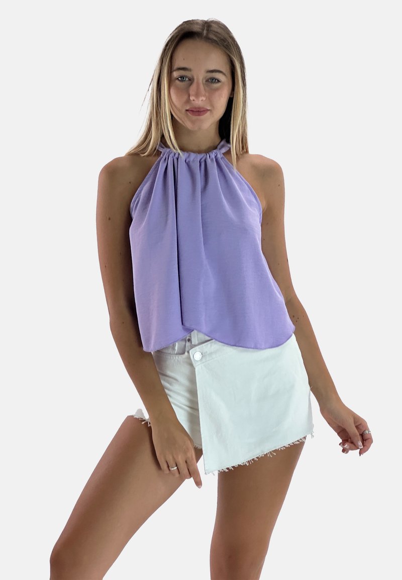 Lila Haltertop mit einem drapierten Vorderteil, kombiniert mit einem weißen Jeans-Minirock mit fransigen Kanten und einem seitlichen Knopfverschluss.