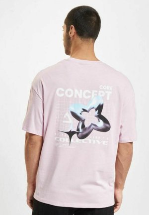 Maglietta in cotone rosa chiaro con maniche corte e stampa grafica sul retro. Presenta forme geometriche e testo in bianco e neri.