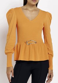 Top lungo a maniche lunghe arancione a coste con scollatura a V, vita peplum e una cintura con dettaglio metallico in vita. Tessuto liscio con maniche voluminose.