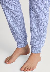 Katoenen pyjamabroeken met een blauw bloemenpatroon, voorzien van ribgebreide boorden en een rechte pasvorm. Het materiaal is zacht en lichtgewicht.