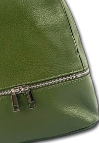 Groene leren tas met een gestructureerde afwerking, voorzien van een zilveren ritssluiting aan de zijkant en een gladde, gestructureerde vorm.