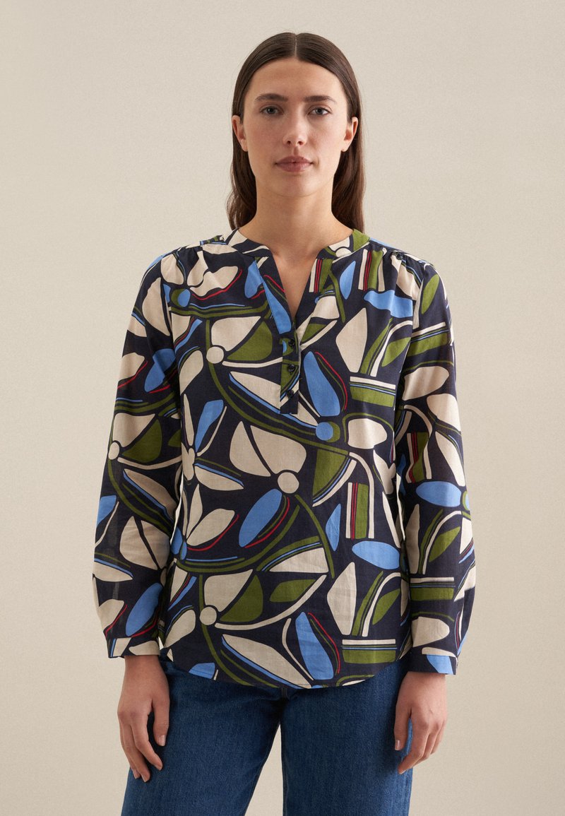 Blusa a maniche lunghe con colletto, caratterizzata da un motivo floreale multicolore nei toni di blu, verde e rosso su uno sfondo blu navy, con dettagli in bottone.