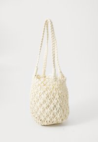 Tote-väska i bomull med makramé, beige färg, cylindrisk form med en texturerad vävd design, utrustad med två flätade handtag för bärande.