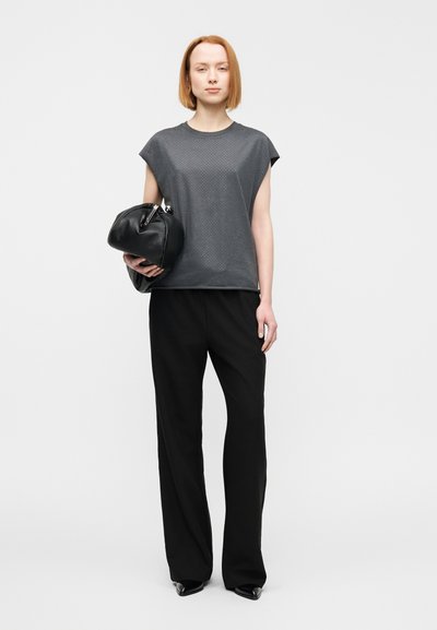 Γκρι μπλουζάκι με κοντά μανίκια και υφασμένη υφή, σε συνδυασμό με μαύρο παντελόνι με φαρδύ πόδι και μαύρη τσάντα pouch. Λείο ύφασμα και άνετη εφαρμογή.