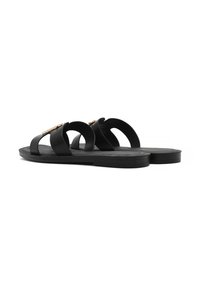 Sandali neri piatti con tre cinghie curve e un accento decorativo dorato sulla parte superiore. Suola testurizzata per una migliore aderenza. Materiale in gomma.