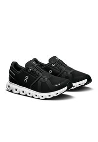Chaussures de sport noires avec une tige en maille et une semelle de confort blanche. Les caractéristiques comprennent des embouts renforcés et un logo de marque contrastant.