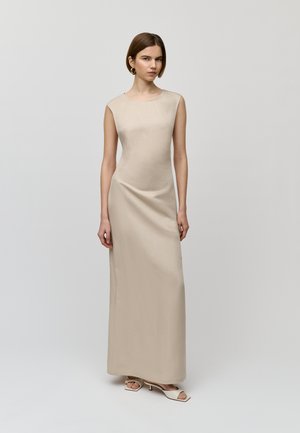 Lang, getailleerde jurk van lichtbeige stof, met een mouwloze stijl en een zachte textuur. Eenvoudig, elegant silhouet zonder zichtbare patronen.