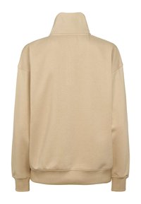 Beežist dressipluus kõrge krae, lõdva lõike ja soonikkoes mansettidega. Pehme tekstuur ja sile pind, nähtamatute mustrite või metallosadeta.