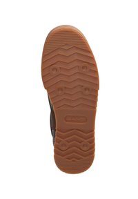 Brown rubber shoe sole with a zigzag tread pattern, circular grip points, and embossed brand name "GANT" near the heel. Size 42 indicated.