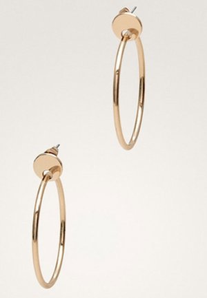 Paire de boucles d’oreilles créoles dorées de taille moyenne avec fermoir à tige sur un fond clair uni.