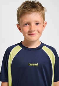 Marinblå funktions-T-shirt med korta ärmar, med limegröna detaljer och en logga i mitten. Slät, lättviktslätt tygstruktur.