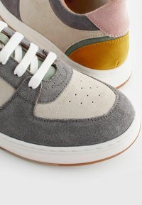 Bunt gefärbte Sneaker mit grauen, pinken, grünen und gelben Wildleder-Paneelen, weißen Schnürsenkeln, perforierter Zehenpartie und einer weißen Gummisohle.
