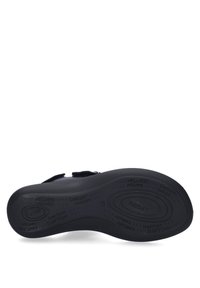 Zwarte sandaal met verstelbare band, zachte gevoerde zool en een getextureerde onderkant. Beschikt over reliëf wellness-branding en is ontworpen voor comfort.