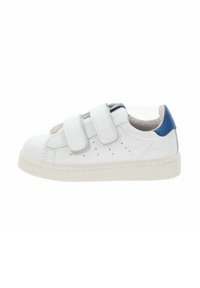 Baskets blanches avec deux bandes Velcro, petites perforations sur le côté, semelle texturée et languette de talon bleue.