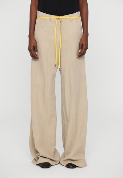 Pantalons larges beige en tissu léger, dotés d'une taille à cordon jaune, de poches à l'avant et d'une coupe décontractée.