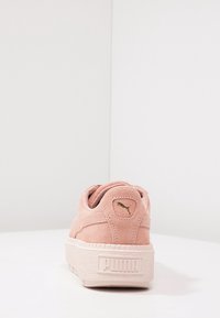Rosa Wildlederschuh mit einer strukturierten, dicken Gummisohle. Merkmale ein goldenes Logo an der Ferse und ein markantes, mehrschichtiges Panel-Design.