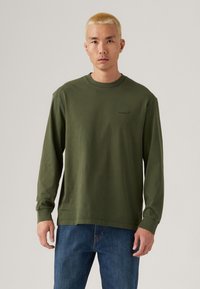 Olijfgroene langemouwen T-shirt met ronde hals, gemaakt van katoen, met een klein logo op de borst en een relaxte pasvorm.