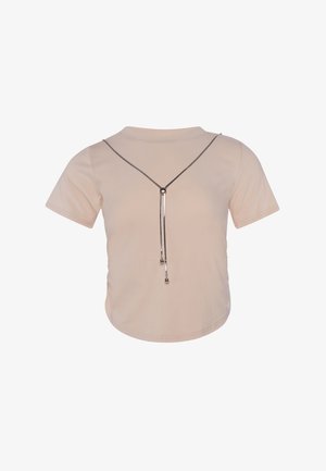 Beige cropped top met korte mouwen en een zilverkleurige ketting in V-vorm met twee hangende bolvormige hangers aan de voorkant.