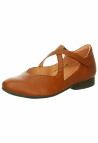 Scarpa piatta in pelle marrone con punta arrotondata, lati scavati e una cinghia a metà piede. Finitura testurizzata e tacco in gomma basso.