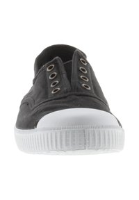 Zapato de lona negro sin cordones con una suela de goma blanca, que presenta ojales redondos y un diseño minimalista. Textura suave, forma simple.