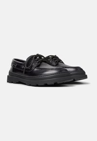 Black leather boat shoes with round toe, stitched detailing, black laces, and a rugged rubber sole for grip and durability.