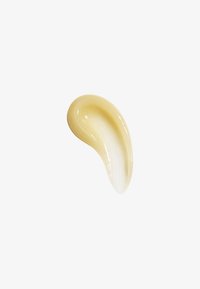 Gekrümmter Streifen aus beiger Creme oder Lotion mit glatter Textur auf einfachem weißen Hintergrund.