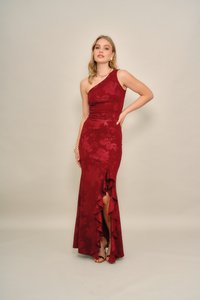 Bordeauxrode asymmetrische jurk met bloemenpatroon, nauwsluitend lijfje, uitlopende rok en gerafelde zoom met een split aan de voorkant. Gladde textuur.