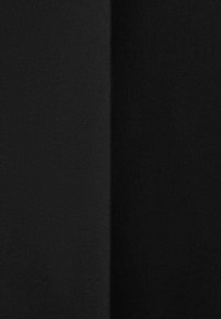 Dos paneles de tela negra texturada, en tonos contrastantes. Un lado parece más suave, mientras que el otro tiene un acabado ligeramente áspero.