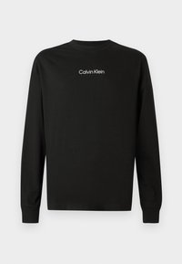 Sort langærmet crewneck trøje med "Calvin Klein" logo centreret på brystet i hvid tekst, plain baggrund.