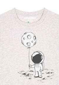 Lichtgrijze t-shirt met een zwart astronautenafbeelding die een maanvormige ballon vasthoudt, met details in de gezichtsvisier en textuur in de stof.