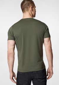 Oliwkowa koszulka z krótkim rękawem o okrągłym dekolcie, wykonana z miękkiej tkaniny. Prosty design z dyskretnym logo z tyłu.