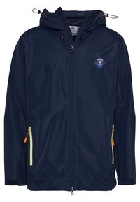 Granatowa wodoodporna kurtka z zamkiem błyskawicznym z przodu, regulowanym kapturem i dwoma bocznymi kieszeniami z żółtymi zamkami. Posiada niebieską naszywkę z logo w kształcie diamentu.