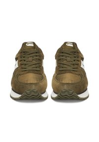 Olivzaļas krāsas zamšāda kedas ar baltām un melnām detaļām, kurām ir teksturētas zolītes, apaļas šņorītes un ērtas apaļas formas dizains.