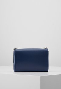 Sac à main en simili cuir texturé bleu marine de forme rectangulaire, avec des ferrures en métal argenté et une fermeture éclair simple.