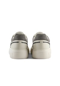 Sneakers bianchi con finitura in pelle liscia, dettagli in suede grigio, tallone rinforzato e suola in gomma testurizzata. Logo stampato sul tallone.