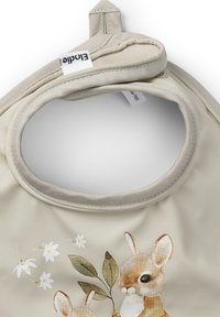 Beige silikonbib med två illustrerade kaniner, omgivna av vita blommor och gröna blad, med en mjuk tygöppning för nacken.