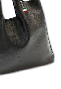 Zwarte leren handtas met een gestructureerde afwerking, in een rechthoekige vorm, met een klein Italiaans vlaggetje hangend eraan.