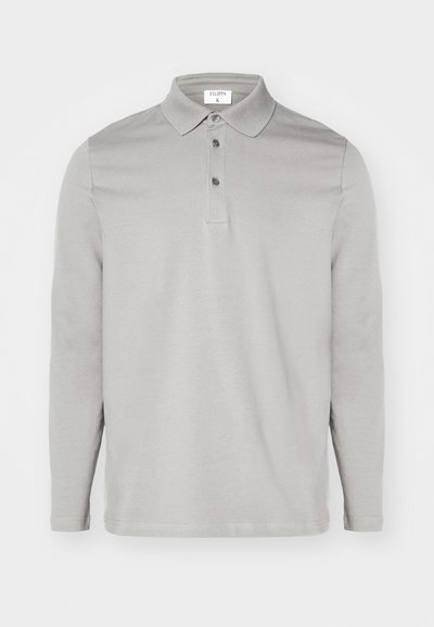 Gaišs pelēks krekls ar garām piedurknēm, izgatavots no mīksta auduma. Tam ir klasiskas atloks, trīs pogu aizdare un smalkas izšūšanas detaļas.