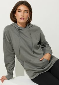 Grijze hoodie van zachte stof, met een voorzak, een aantrekkoord bij de kap en een relaxte pasvorm met geribbelde manchetten.