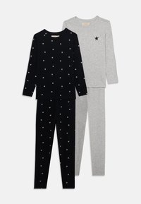 Two sets of pajama tops and bottoms: one black with white star patterns, and one gray with a single black star. Soft cotton material.