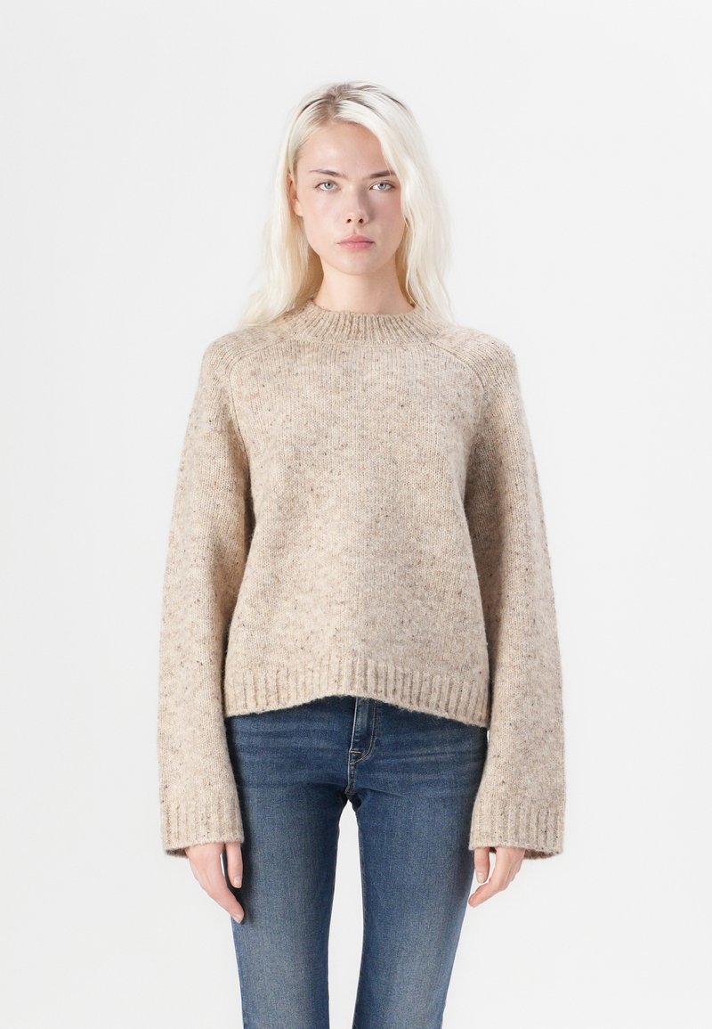 Beiger Strickpullover mit grober Textur, geripptem Saum und weiten Ärmeln. Verfügt über einen runden Halsausschnitt und ein leicht verkürztes Design.