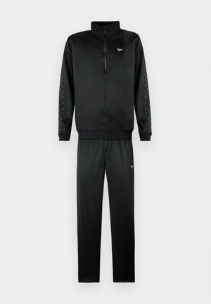 Fato de treino preto com uma jaqueta com fecho e gola alta e calças combinando. Feito de um tecido suave, apresentando detalhes texturizados nas laterais.