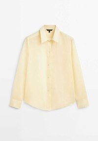 Chemise manches longues jaune clair en tissu léger. Comprend un col classique, une patte de boutonnage et un ourlet légèrement incurvé.