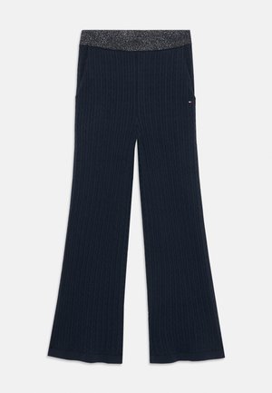 Marina ribbade byxor med utsvängd nederdel, med en glittrig midja och sidofickor. Texturerad tyg ökar det visuella intresset.