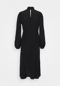 Robe noire à manches longues avec un col haut, dos avec une ouverture en forme de clé, tissu texturé présentant de petits motifs et manches légèrement bouffantes.