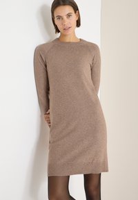 Bruine gebreide jurk met lange mouwen, ronde hals, geribbelde zoom en een zachte textuur, ontworpen voor een losse pasvorm en een casual stijl.