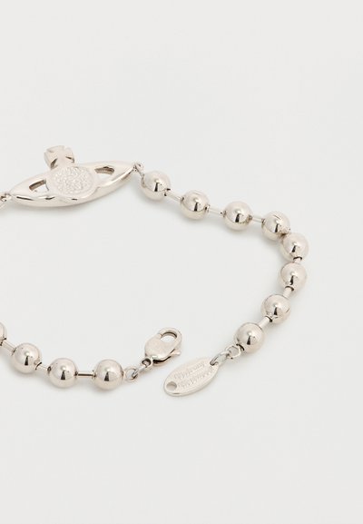 Ασημένιο κολιέ με χάντρες που διαθέτει κεντρικό οβάλ μενταγιόν με σταυρό και κλείσιμο με κούμπωμα αστακού, συνοδευόμενο από ανάγλυφη ταμπέλα επωνυμίας.