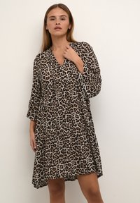 Leopardmönstrad klänning i lätta tyger. Har en V-ringning, trekvartsärmar, lagerdesign och en avslappnad passform med rundad nederkant.